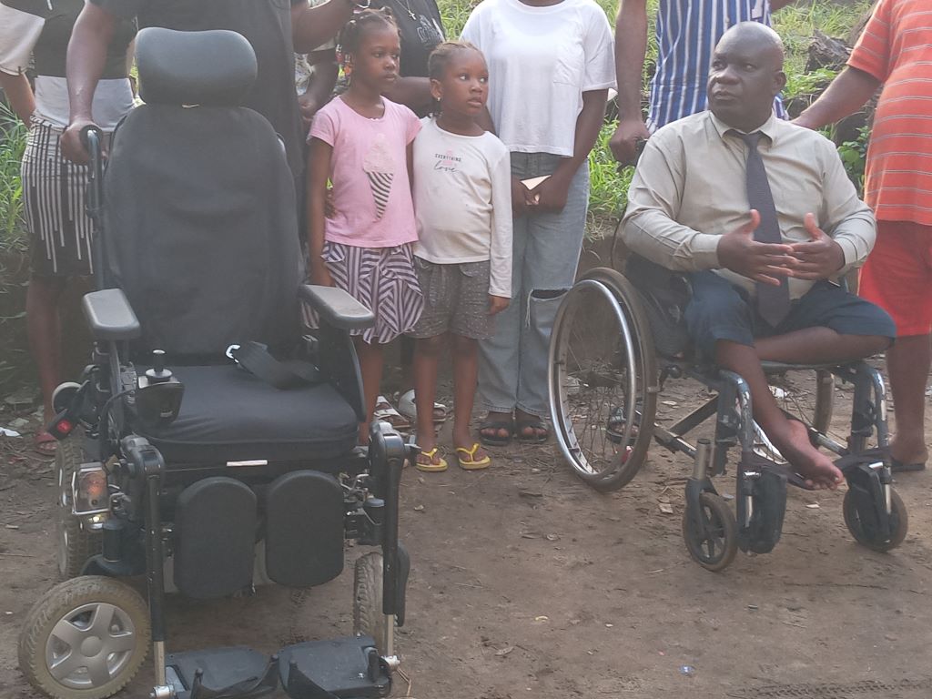 Cocody / Eric Taba offre un fauteuil roulant électrique à un habitant de la Sogefiha